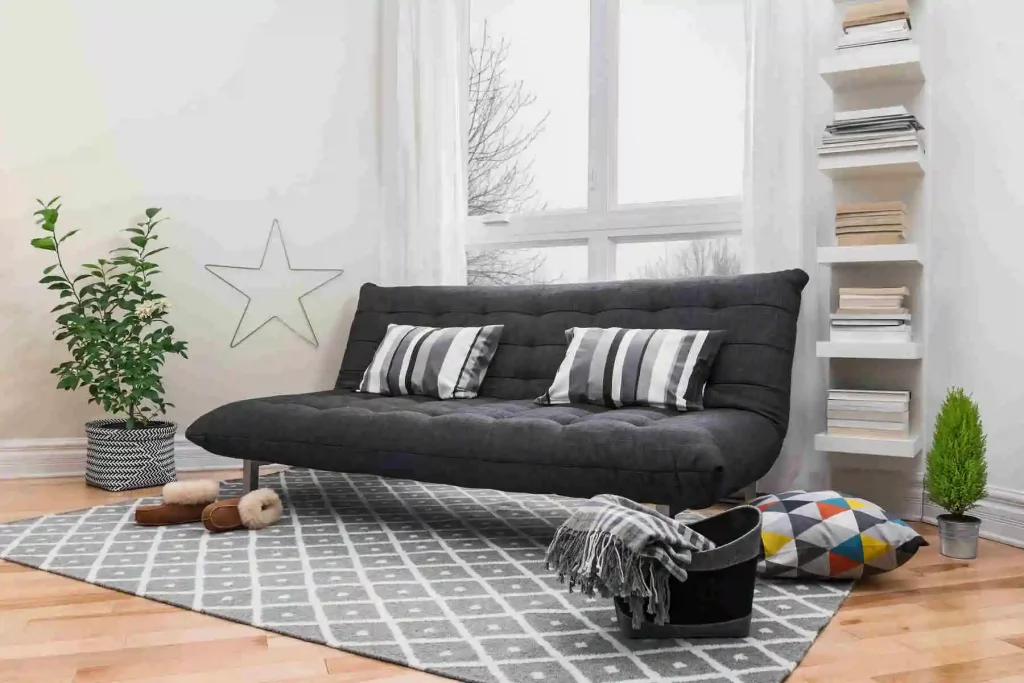 Sofá cama preto fosco em uma sala de estar no estilo futon