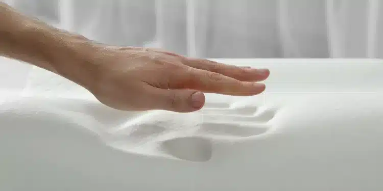 Mão masculina pressionando travesseiro de espuma