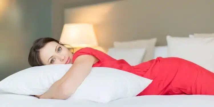 Mulher vestida de vermelho abraçando um travesseiro